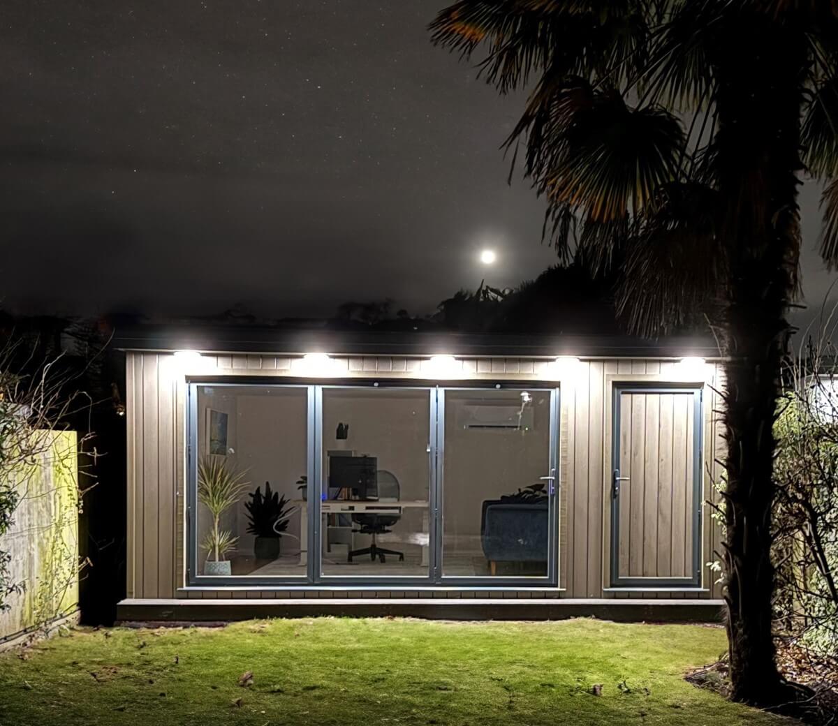 Bespoke spacious garden office with attached garden storage in Woking Surrey, night lighting - Design and built by Garden Rooms by Drumbeat